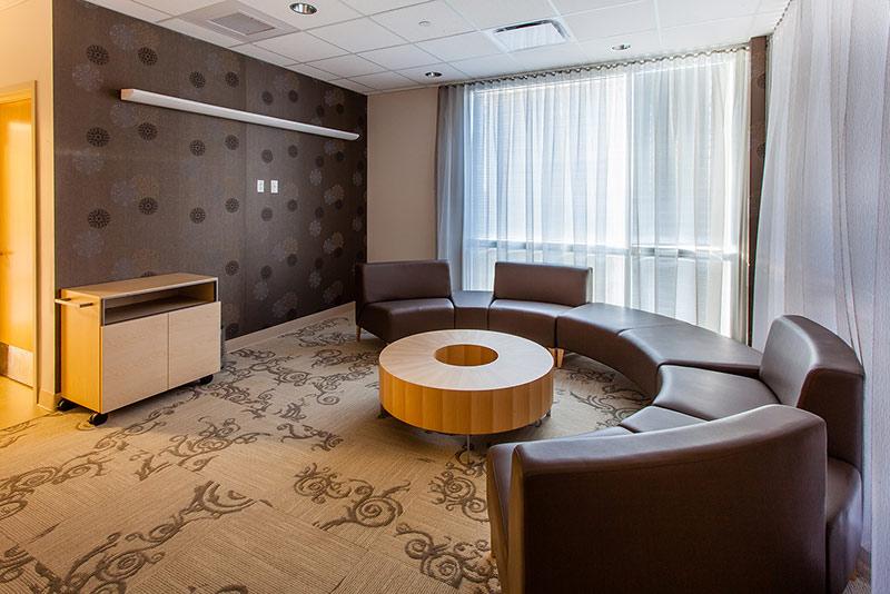 Photo of seating at the California Proton Cancer Therapy Center. Round brown leather couch around doughnut shaped table.